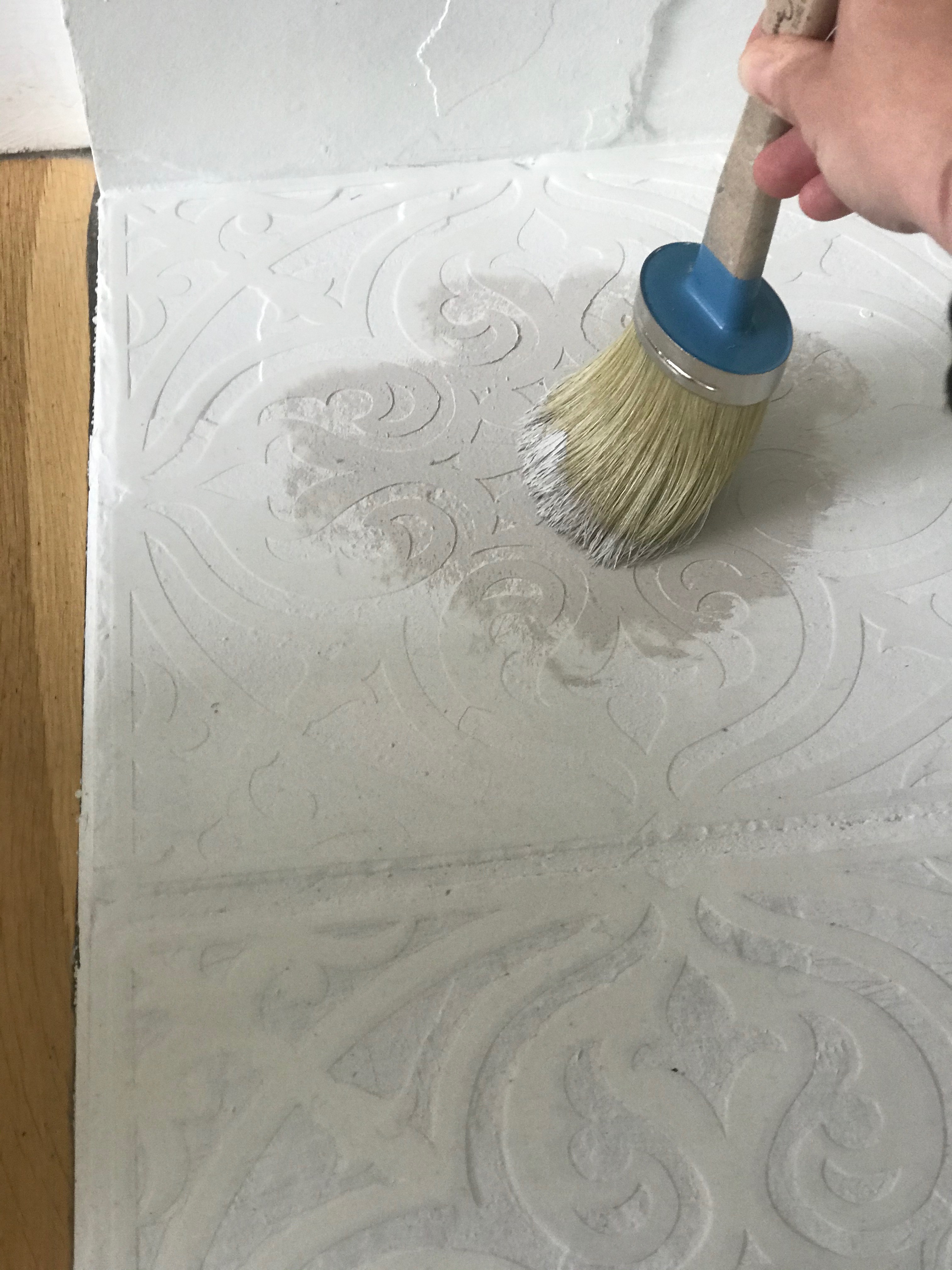 Painting over your stencil for a DIY fireplace mantel makeover