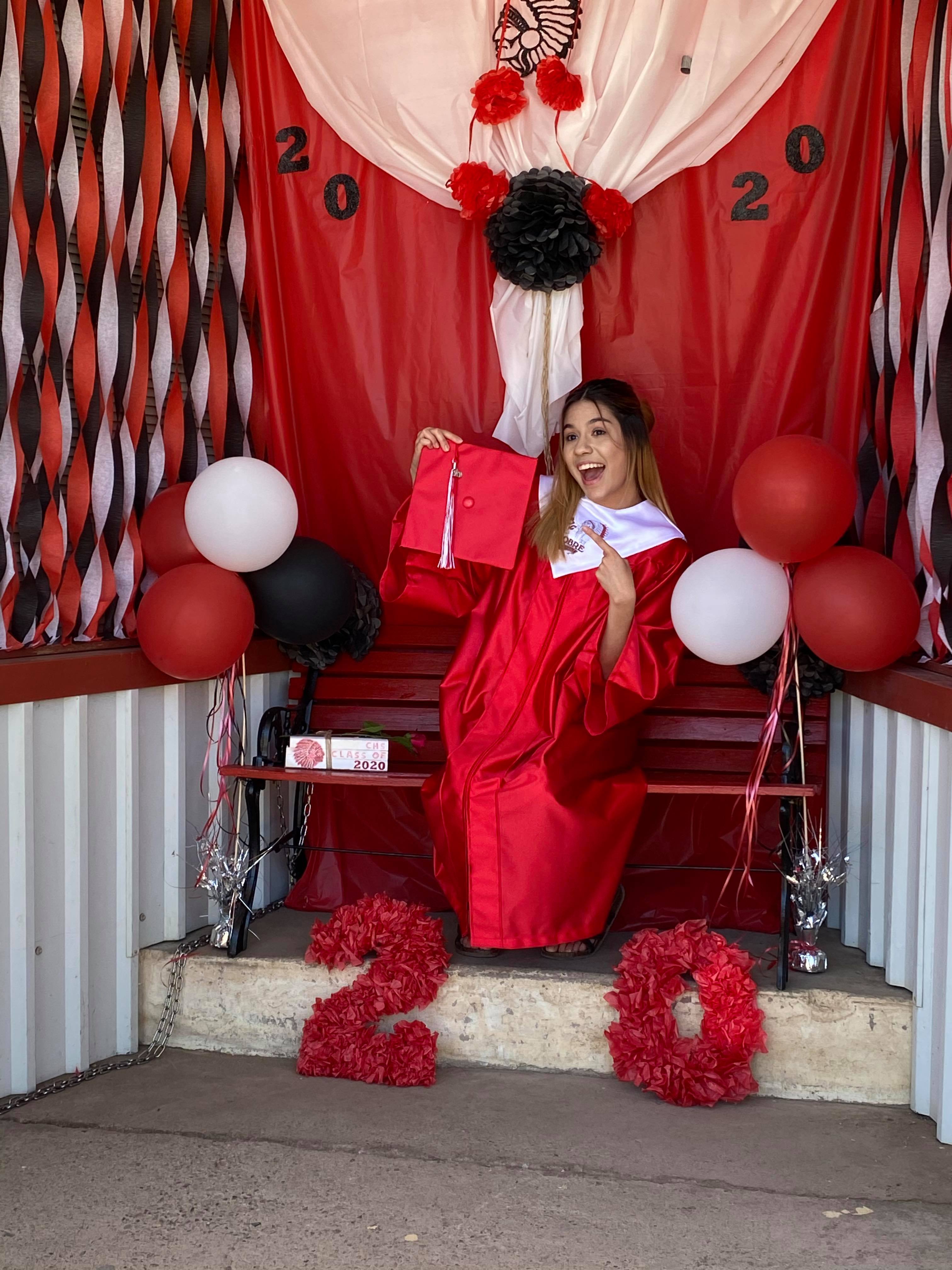 Excited graduate in front of outdoor Cricut graduation photo booth for Cobre High School