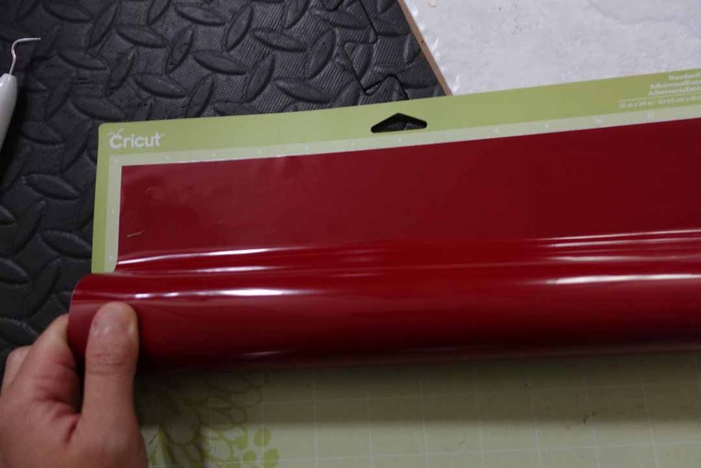 Rolling Cricut vinyl onto its machine mat