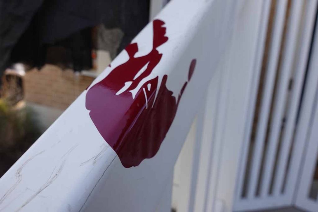 Bloody handprint on front porch banister