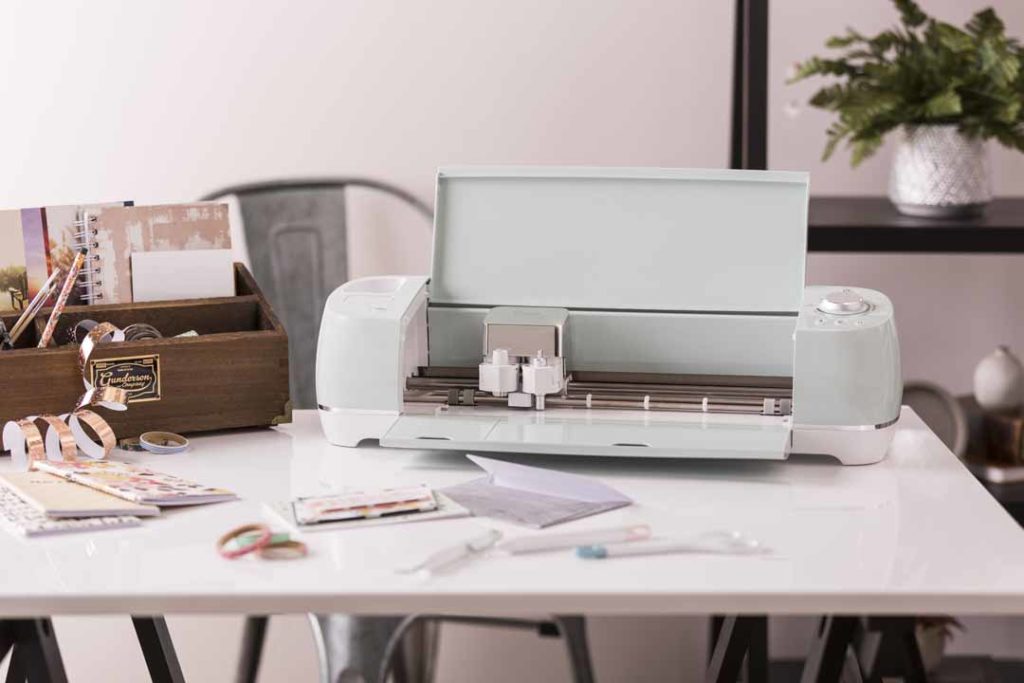 Cricut Explore Air 2 machine on desk with projects