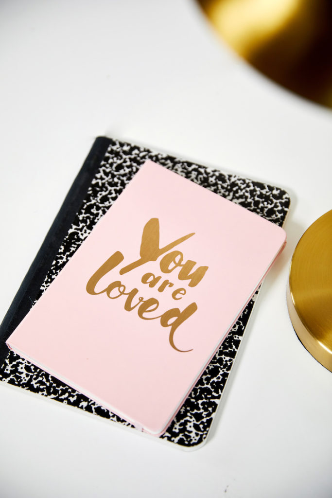 "You are loved" notebook on desk