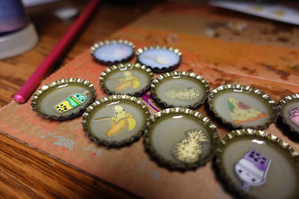 Bottle cap pins made with Cricut Smart Labels and resin or polymer compoound