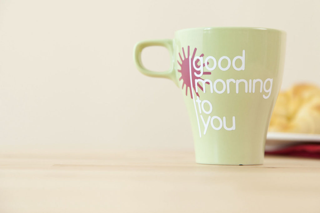 Coffee mug that reads "good morning to you" sitting on table.