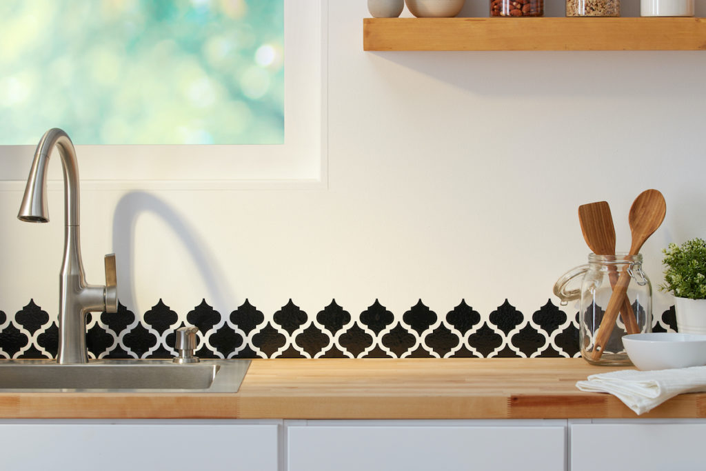 Black vinyl pattern is applied as a backsplash to a beautiful minimalist kitchen.