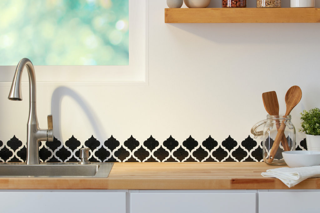 Black vinyl pattern is applied as a backsplash to a beautiful minimalist kitchen. 