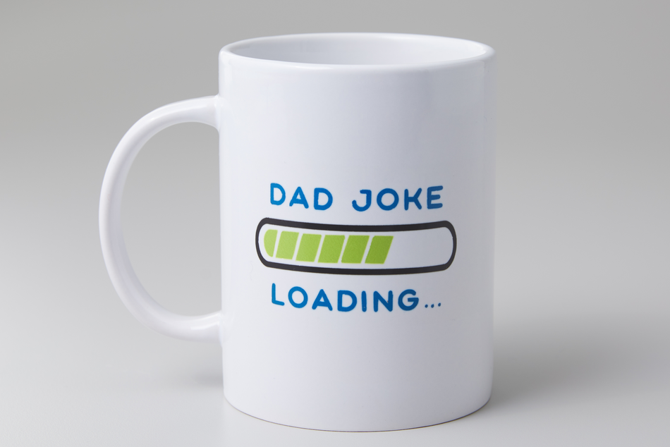 A white mug reading "dad joke loading" sits on an off-white background.