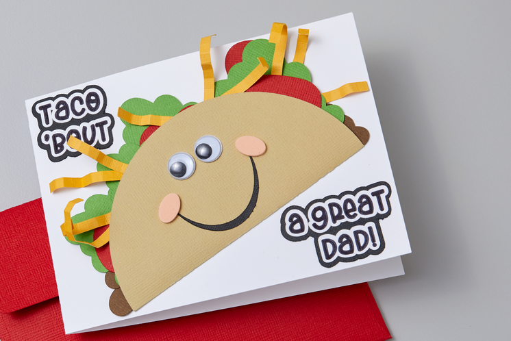 A cute Father's Day card reading "taco bout a great dad" sits on a table