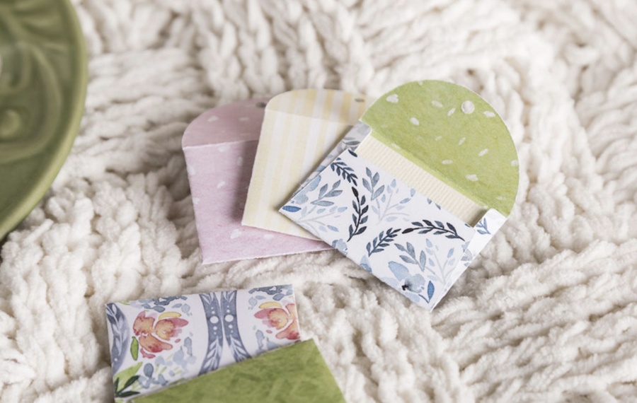 Floral tea bags sit on a white blanket