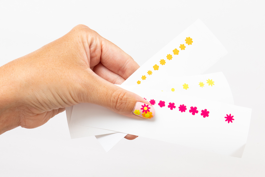 A hand displays a summer nail design created using Cricut permanent vinyl smart material 