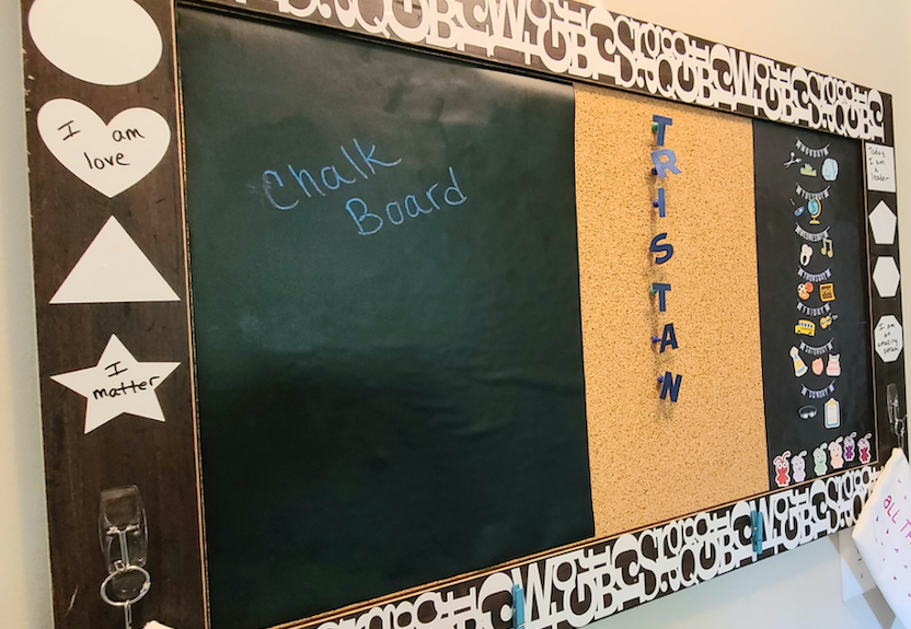 A custom bulletin board for at-home and in classroom learning hangs on a white wall 