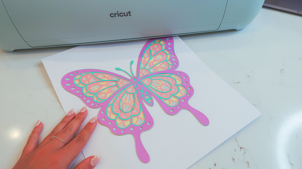 A pastel color butterfly on a piece of white cardstock, designed as dorm room decor