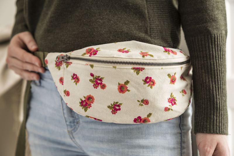 A floral belt bag rests on someone's hip