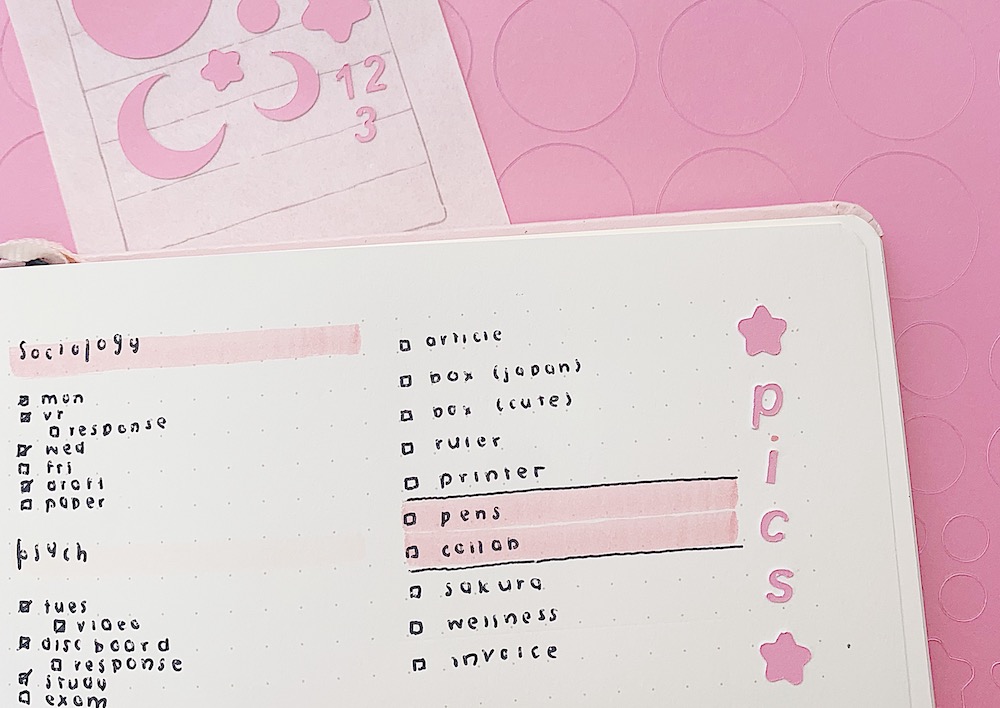 Pink card stock stickers are placed on notebook pages for bullet journaling design 