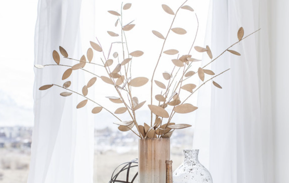 A faux leather tree centerpiece is spray painted in gold to create metallic decor 