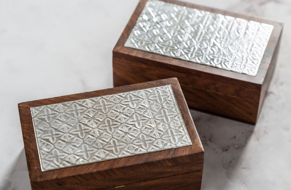 A dark wooden jewelry box is embellished with embossed aluminum foil, serving as metallic decor 