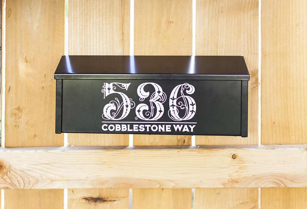 Mailbox personalized to say "536 Cobblestone Way" in pink letters
