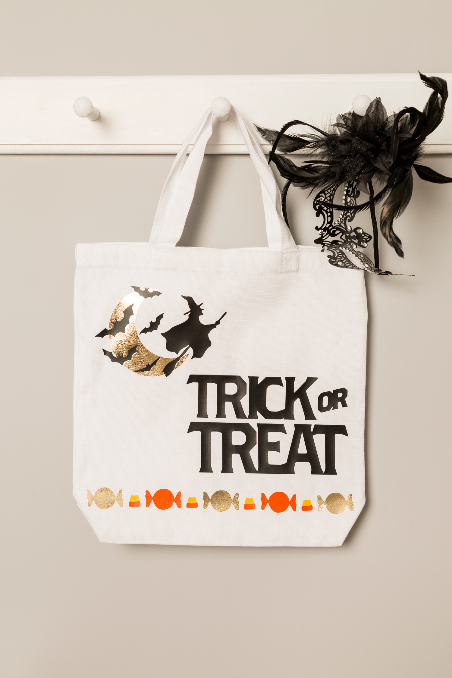 masquerade mask inside trick-or-treat bags hanging on wall
