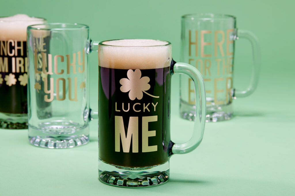 Beer mugs and beer steins decorated with gold vinyl with Cricut for St. Patrick's Day with sayings like "Lucky Me"